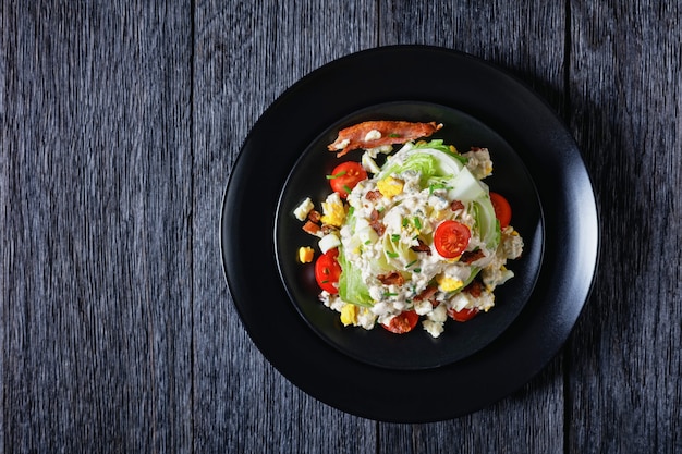 iceberg wedge salad with blue cheese sauce, bacon,  tomatoes, eggs