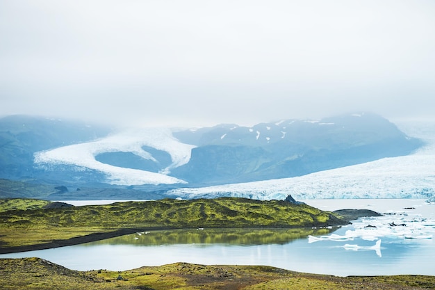 산의 전경을 조망할 수 있는 빙하 호수의 빙산. Vatnajokull 빙하, Fjallsarlon 석호, 아이슬란드 남부