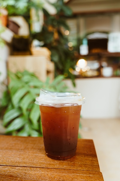 iced americano coffee in takeaway glass on wood table