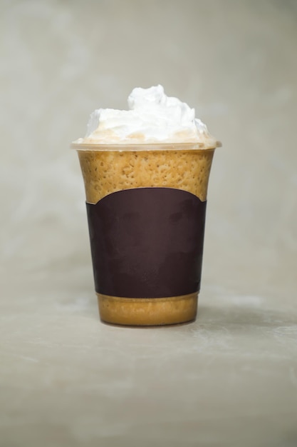 Photo iced blended hazelnut latte coffee served in disposable cup isolated on grey background side view of cafe dessert