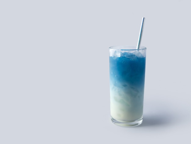 Iced blue butterfly pea latte drink met tropisch bloemdecor. Gezonde Thaise traditionele cocktail in glas