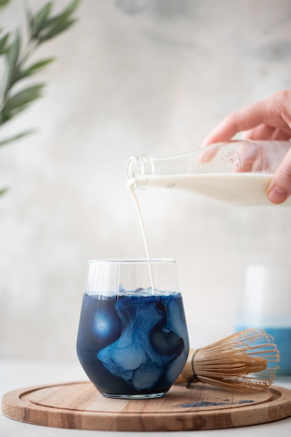 Iced blue matcha tea in glass on a wooden board