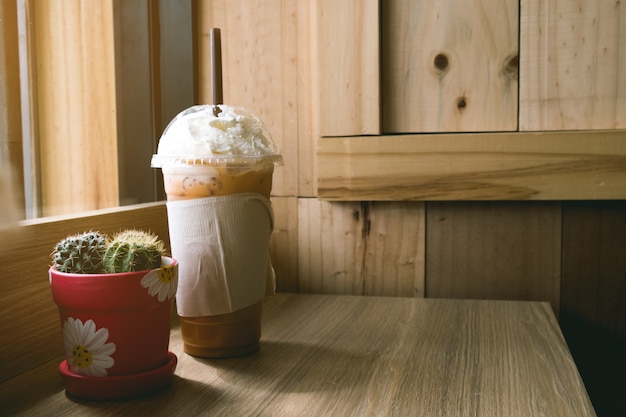 Замороженный капучино с топпинг-кремом на деревянном столе коричневый, фон