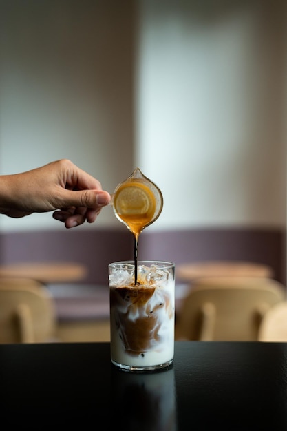 Iced coffee in glass on table in coffee shop blur background