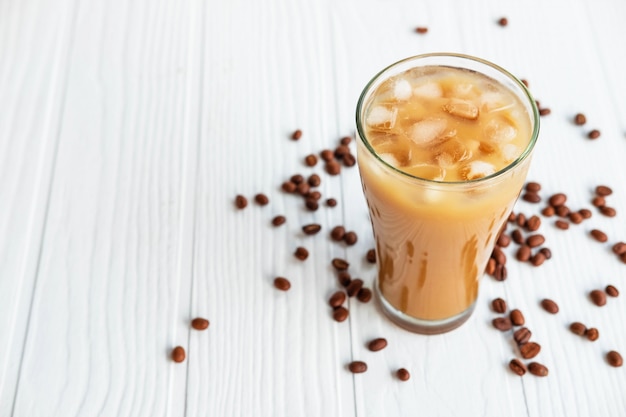 Iced coffee in a glass on a white wooden table