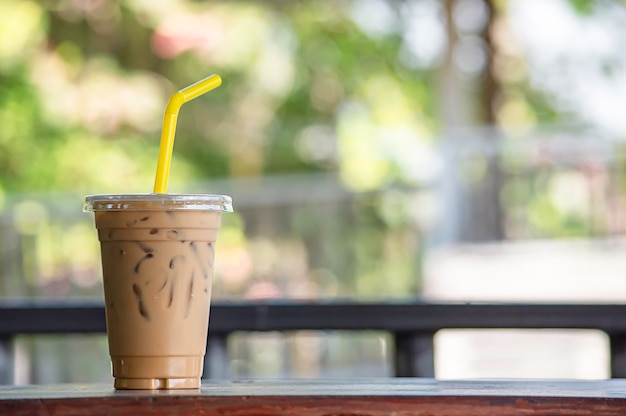 Iced coffee in a glass on the wooden table.