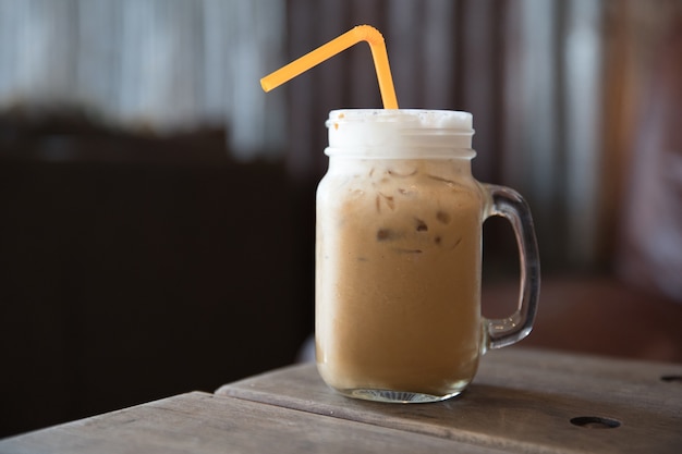 Iced coffee in a jug on the wooden table 