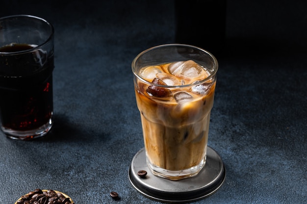 Iced coffee in a tall glass with cream poured over. Iced latte. Cold summer drink. Cold brew in glass. Cappuccino on Ice. Vietnamese Iced Coffee.