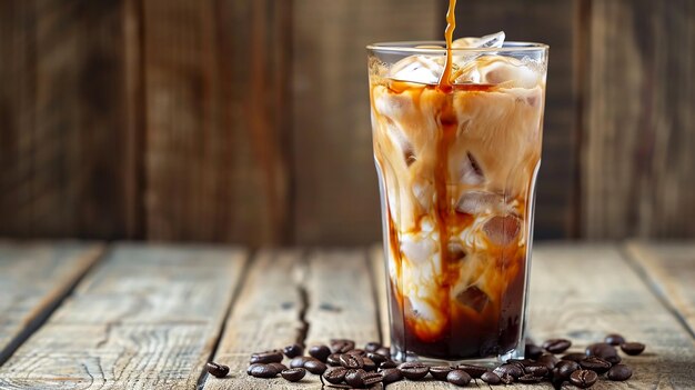 Foto caffe' ghiacciato in un bicchiere alto con la crema versata su sfondo di legno