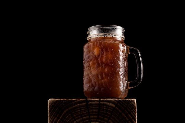 Iced coffee in a tall glass with a handle.