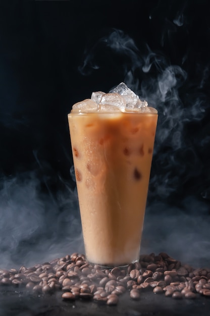 Iced Coffee wiht Milk in Tall Glass and Coffee Beans on Dark Background