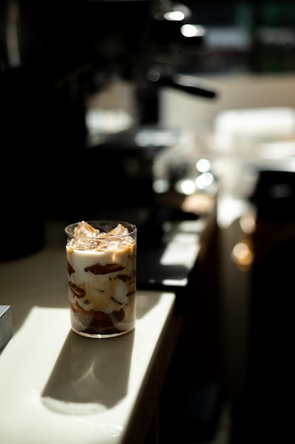 Iced coffee with milk in a glass on the bar counter