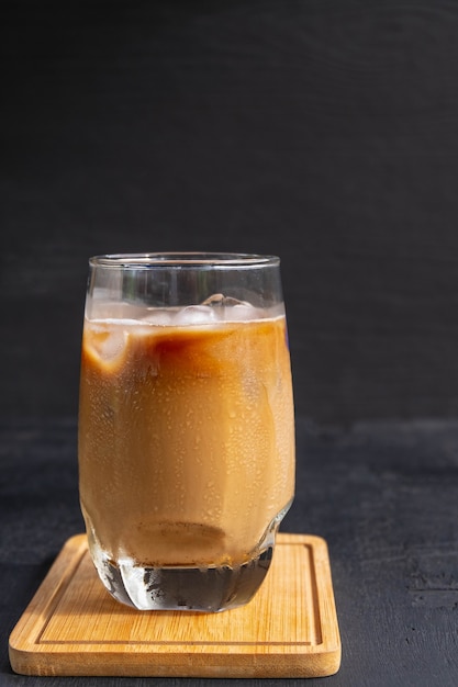 Холодный кофе с молоком в стакане или замороженный капучино.