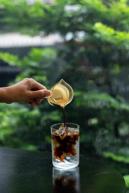 カフェのテーブルの上のグラスにミルクを入れたアイスコーヒー