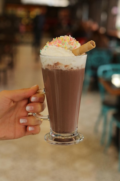 Iced coffee with milk. Iced coffee latte . Woman holding glass cup of iced coffee.