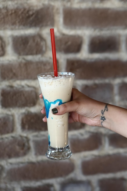 Iced coffee with milk. Iced coffee latte . Woman holding glass cup of iced coffee.