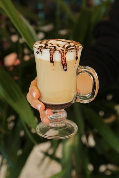 Iced coffee with milk. Iced coffee latte . Woman holding glass cup of iced coffee.