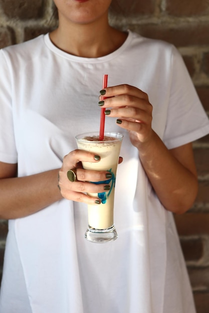 Iced coffee with milk Iced coffee latte  Woman holding glass cup of iced coffee