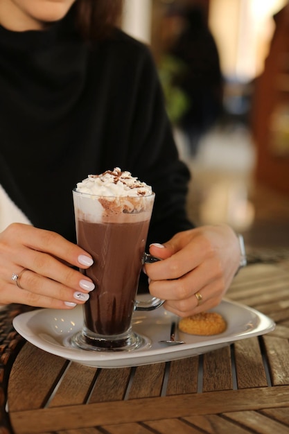 Iced coffee with milk Iced coffee latte Woman holding glass cup of iced coffee