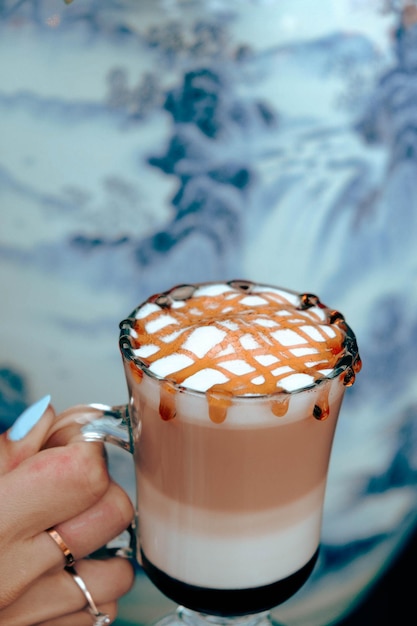 Iced coffee with milk. Iced coffee latte . Woman holding glass cup of iced coffee.