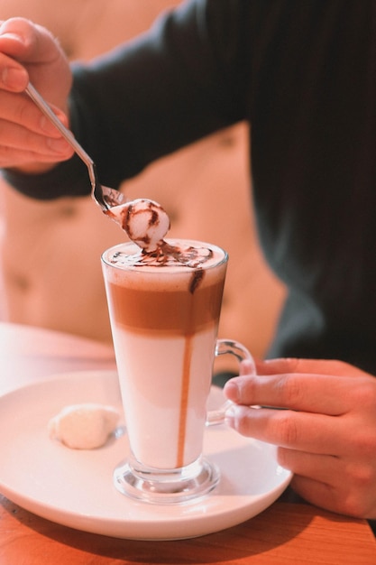 Iced coffee with milk. Iced coffee latte . Woman holding glass cup of iced coffee.