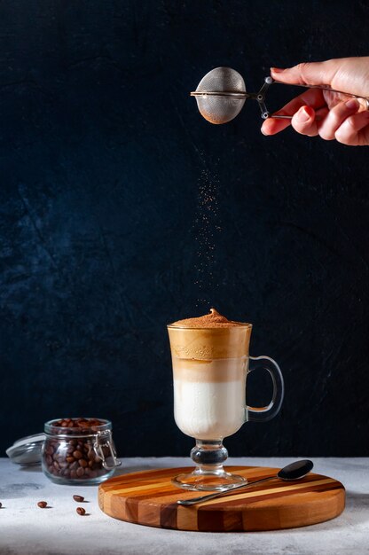 Iced Dalgona coffee in a glass on dark background