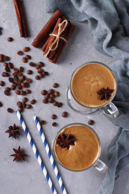 Iced dalgona-koffie in hoge glazen met kruiden op lichtgrijze betonnen ondergrond. trend in koreaanse romige slagroomkoffie. uitzicht van boven