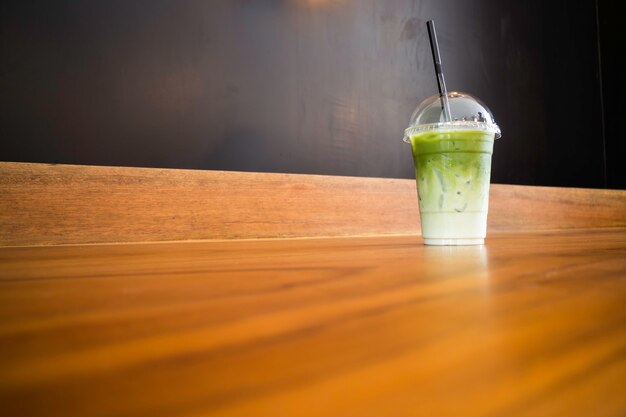 Iced green tea latte on wooden table