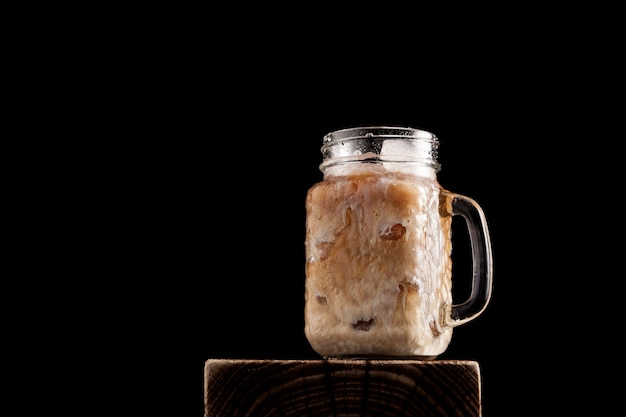 Iced latte coffee in cup glass on black background. Close-up, copy space.