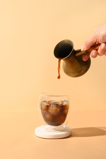 Iced latte coffee in cup glass with pouring milk