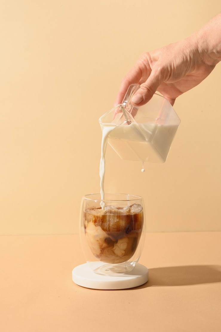 Photo iced latte coffee in cup glass with pouring milk