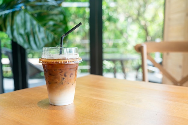 кофе со льдом латте в стакане на вынос на столе в кафе, кафе и ресторане