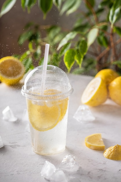 Iced lemonade with soda in plastic glass on the table