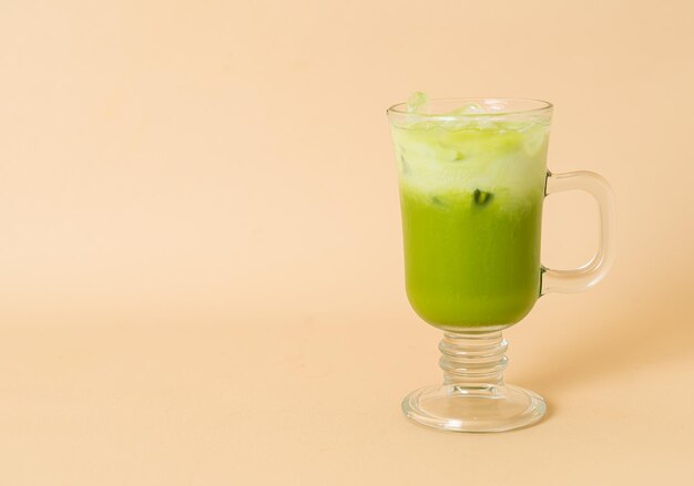 iced matcha green tea latte with milk layer in glass