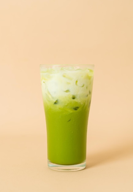 iced matcha green tea latte with milk layer in glass