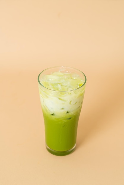 iced matcha green tea latte with milk layer in glass