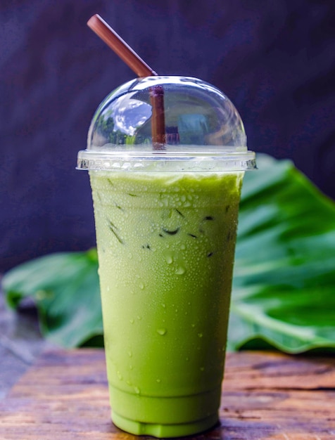 Iced matcha latte green tea with milk in a plastic glass with ice