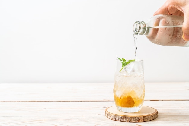 iced plum juice with soda and peppermint on wood table - refreshment drink