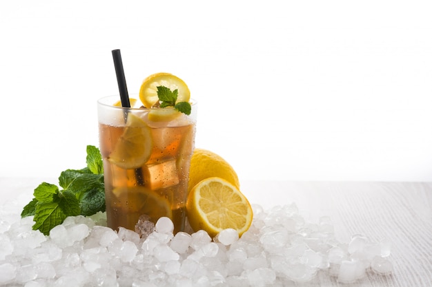 Iced tea drink with lemon in glass and ice