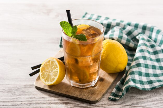 Iced tea drink with lemon in glass and ice