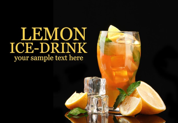 Iced tea with lemon and mint on black background