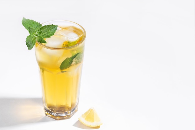 iced tea with mint and lemon on a white background and with a hard shadow