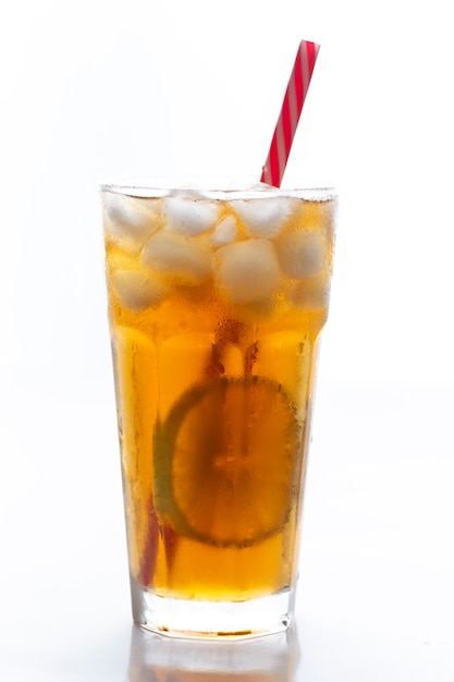 Iced tea with straw, ice cubes and sliced lemon over white background