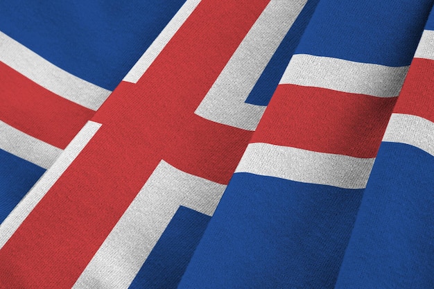 Iceland flag with big folds waving close up under the studio light indoors The official symbols and colors in banner