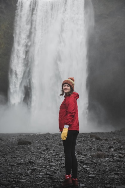 アイスランドの風景。水の壁の前に立っている女の子