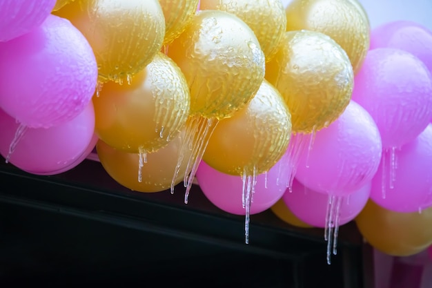 Icicles on frozen colored inflatable holiday balls winter weather season street interior details