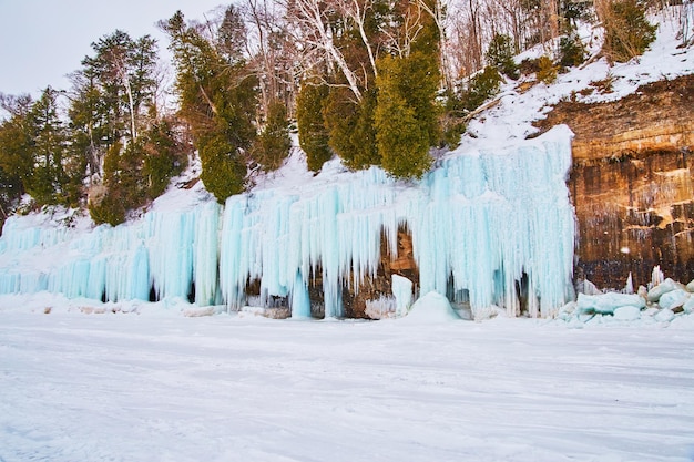 Icicles and ice formations blue frozen to rocky cliffs