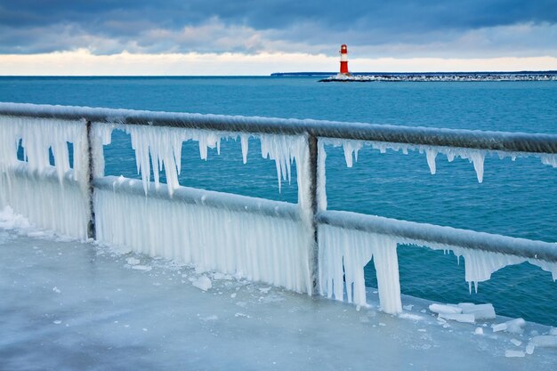 Foto icicles op de reling met vuurtoren op de achtergrond