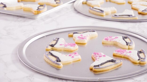 Icing figure skate shaped sugar cookies with royal icing.