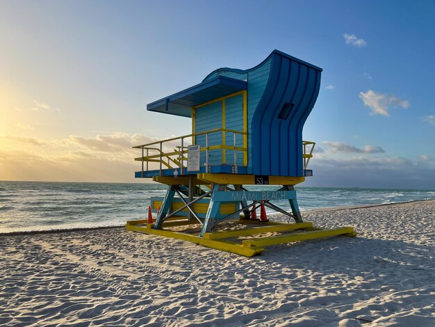 Iconic blue and yellow lifeguard house in Miami Beach Beautiful sky at sunrise